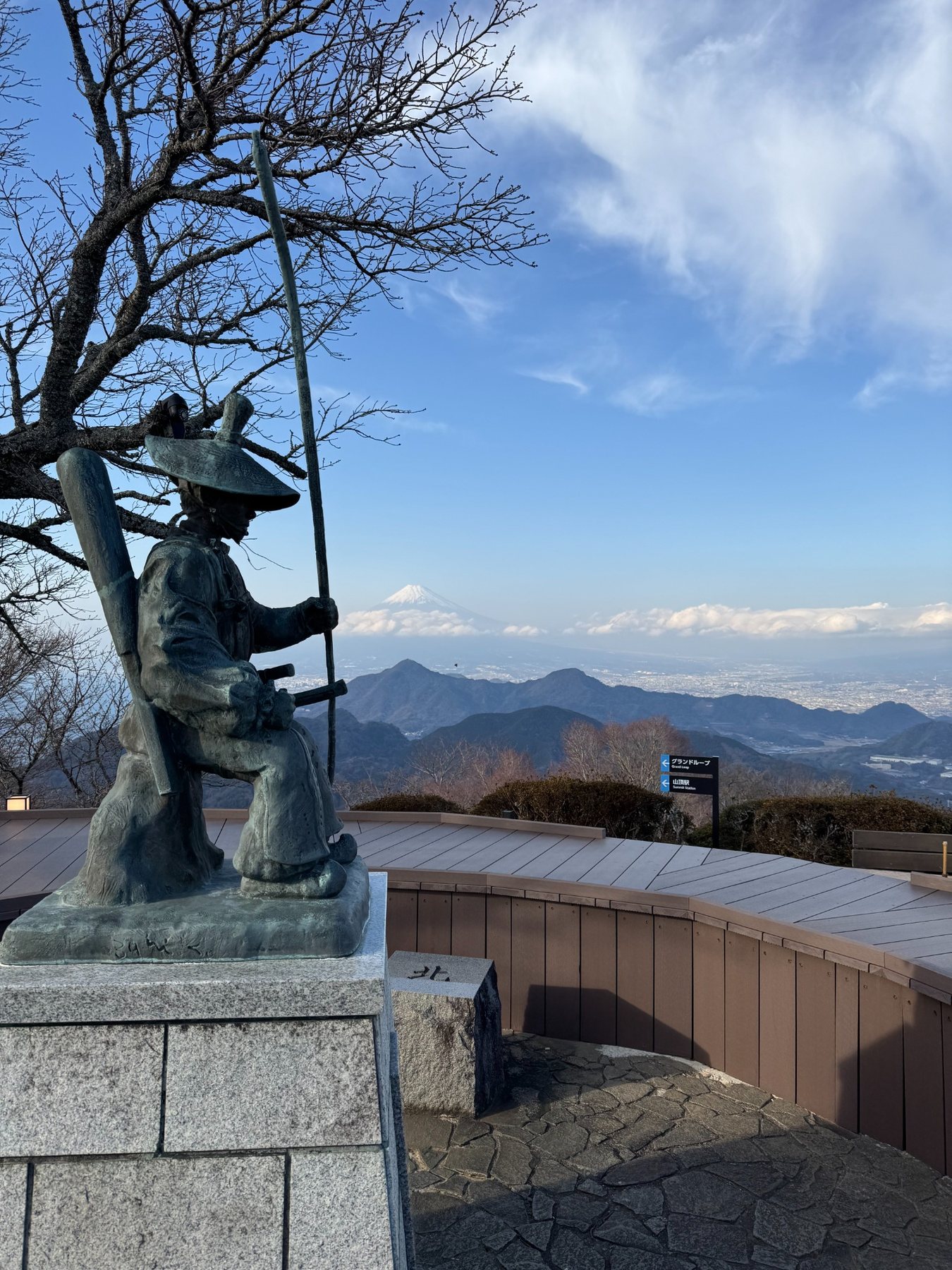 View of Mount Fuji from Izu with a historic warrior statue in the foreground
